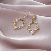 Elegant gold-plated heart flower drop earrings with sparkling green and white stones, crafted from crystal and cubic zirconia.